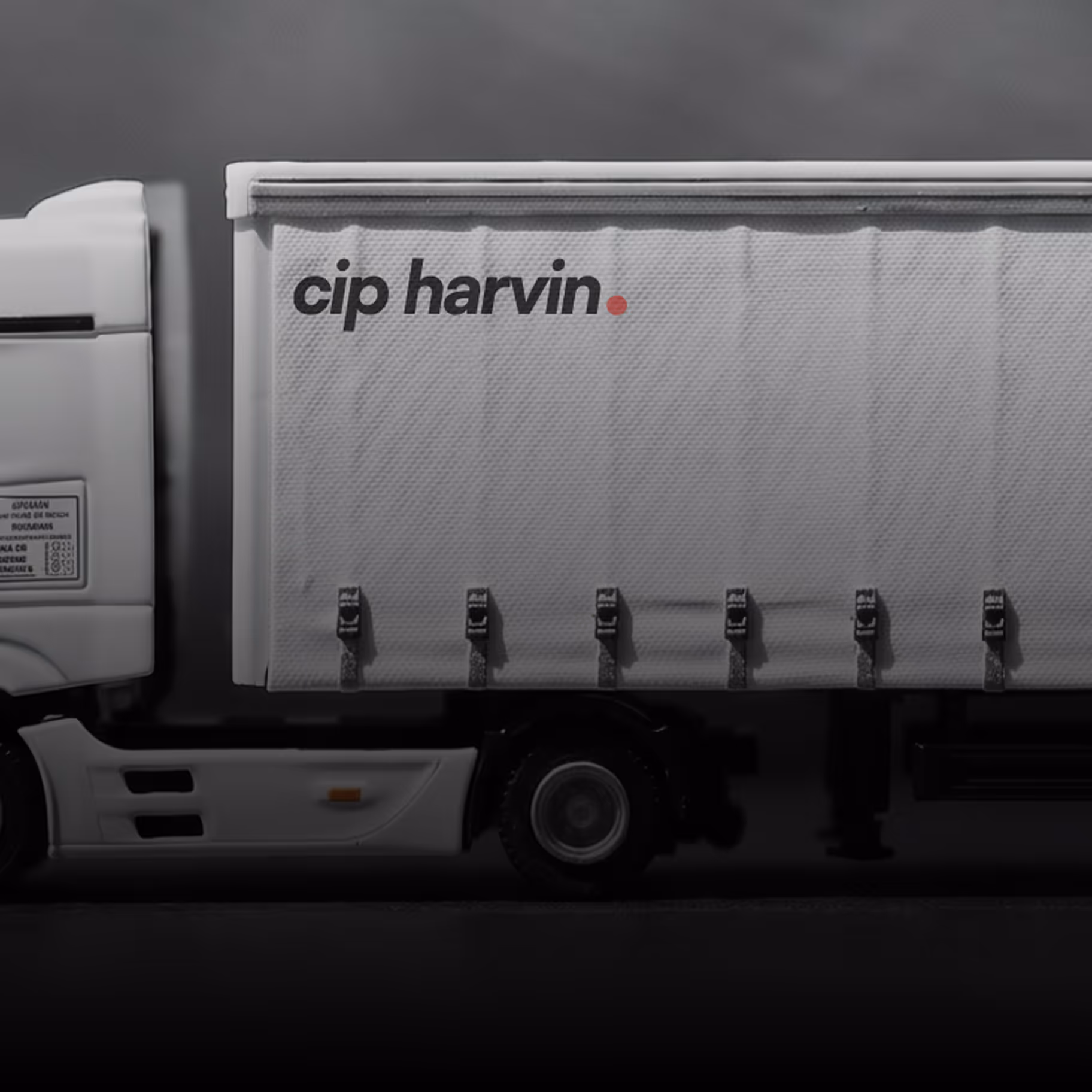 Side view of a white truck trailer with the text 'cip harvin.' on its side.