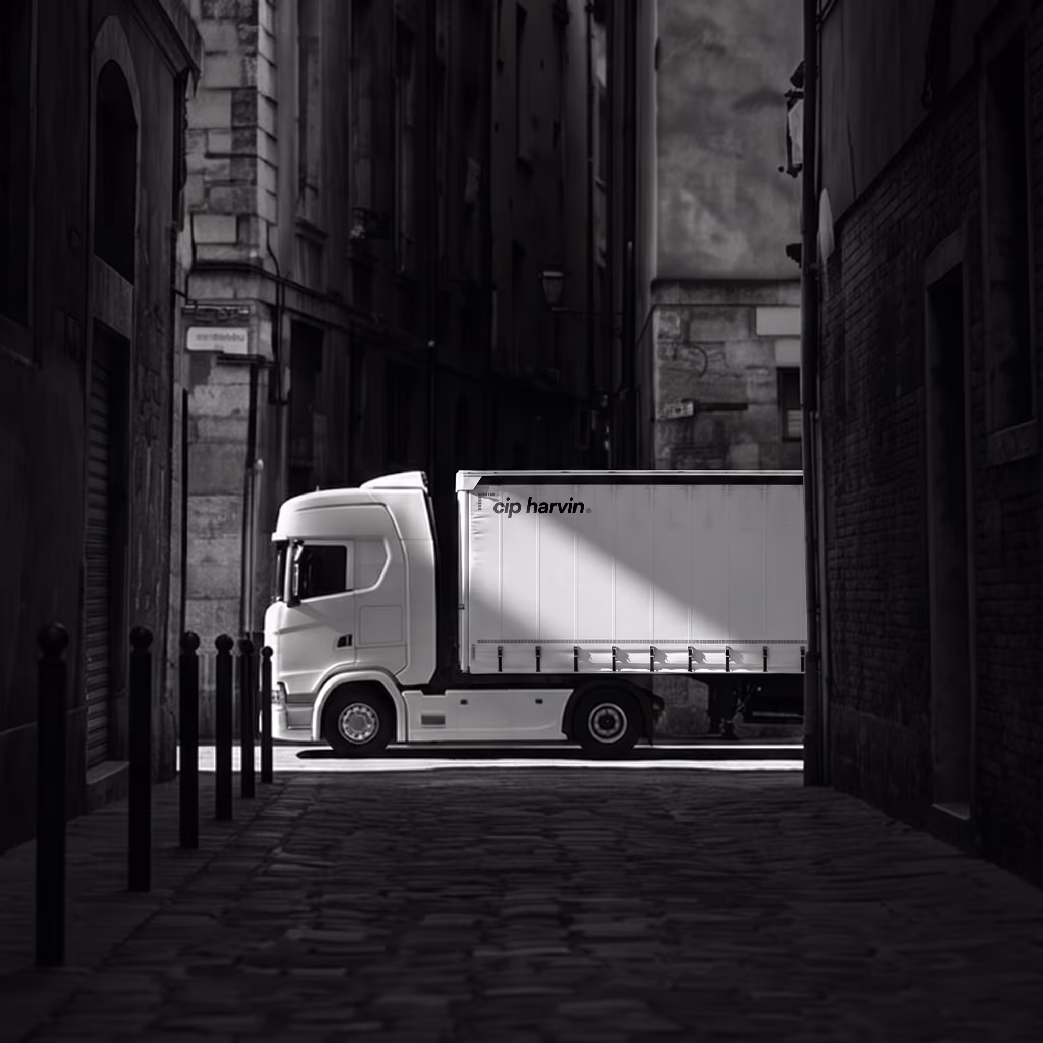 White cargo truck with Cip harvin logo on it parked in a narrow cobblestone street between old stone buildings with shadows.